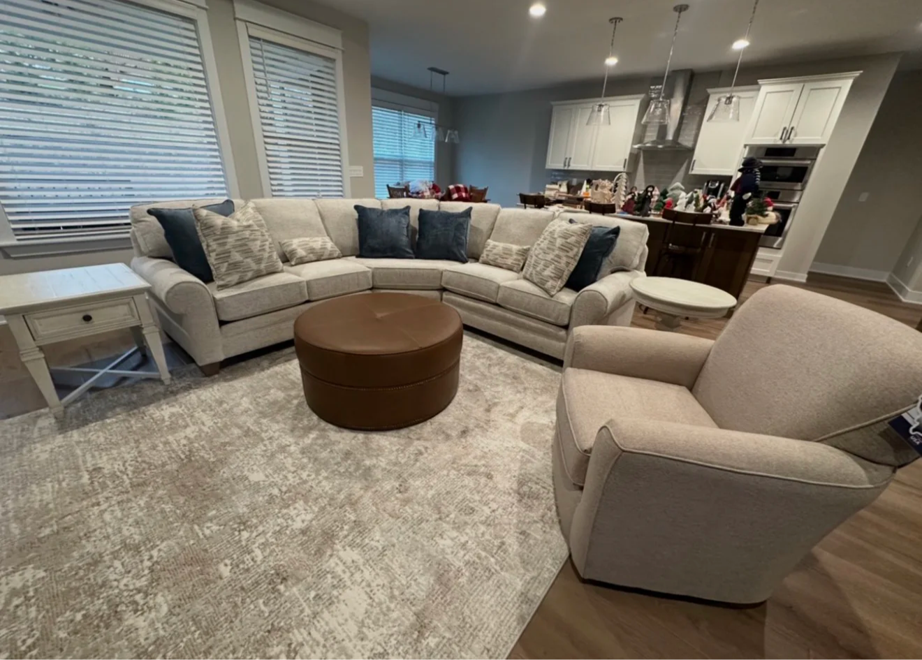 Living room with a sectional sofa, round coffee table, and armchair.