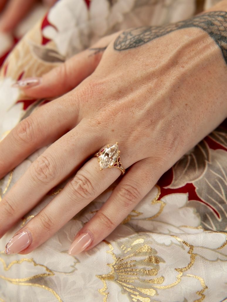 close up of marquise diamond ring with ruby accents