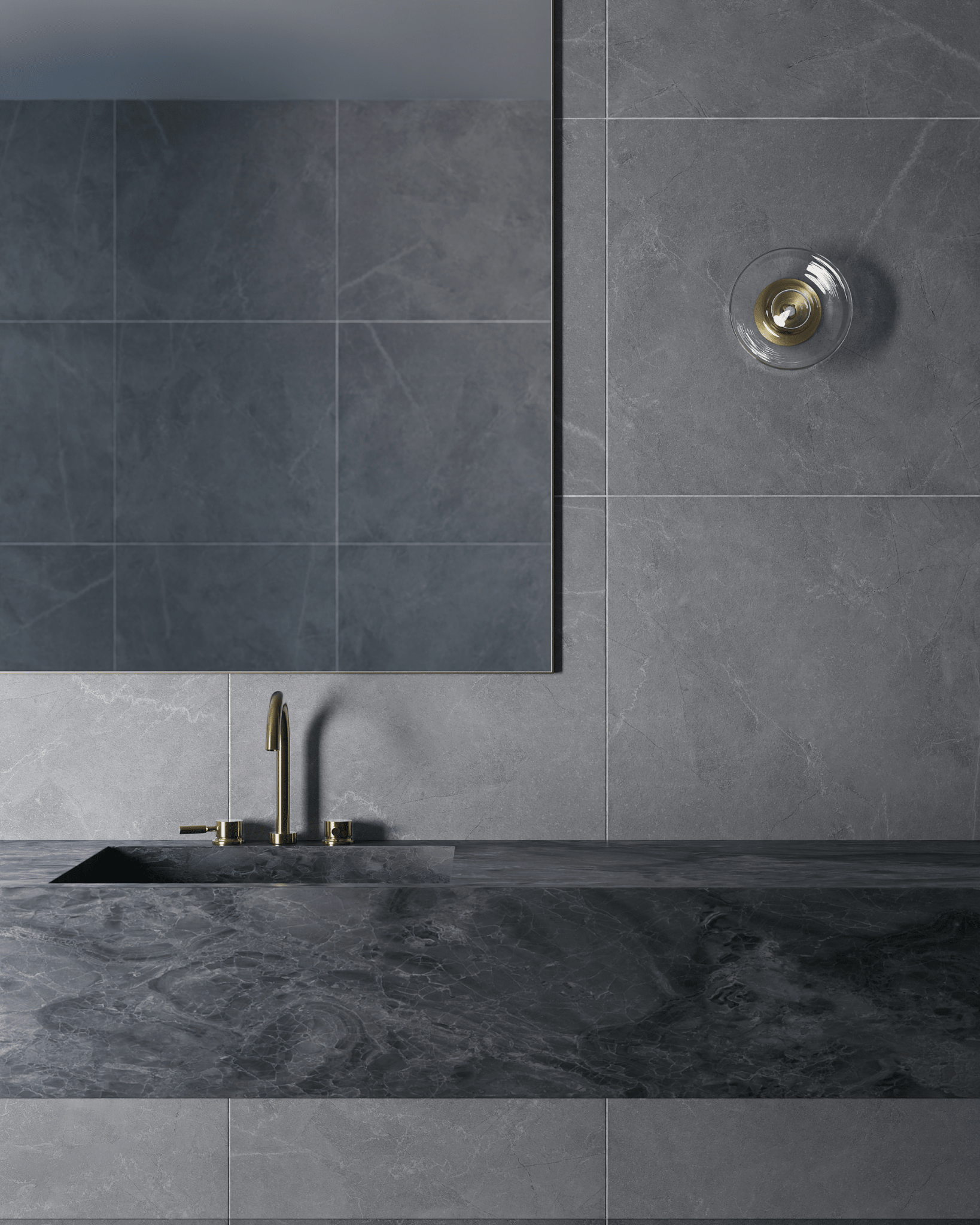 Grey tiled wall with a sink and gold faucet, glass wall light
