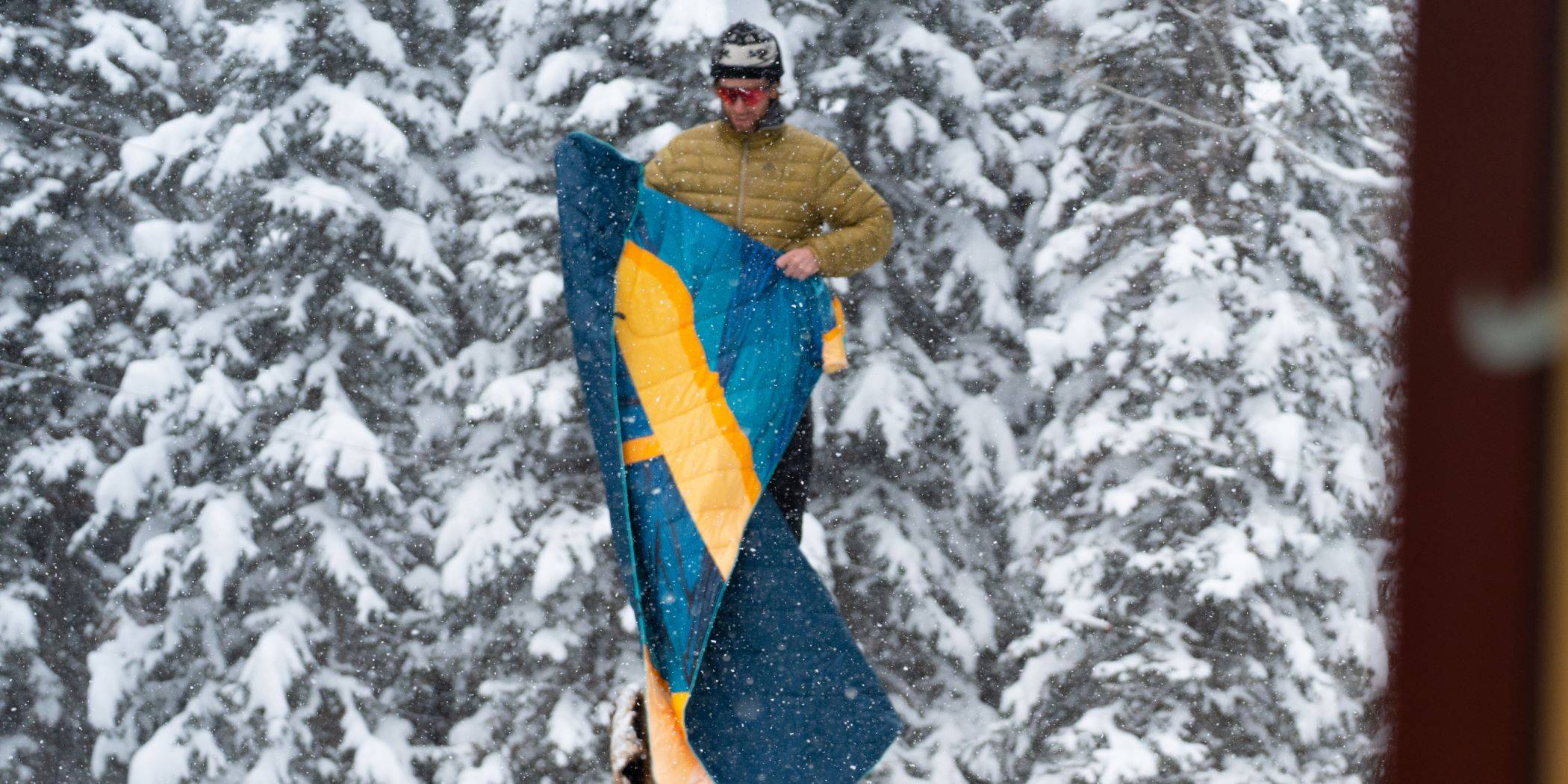 Joseph Toney in his snowy element - holding up the Original Puffy Blanket - Ridgeline Views