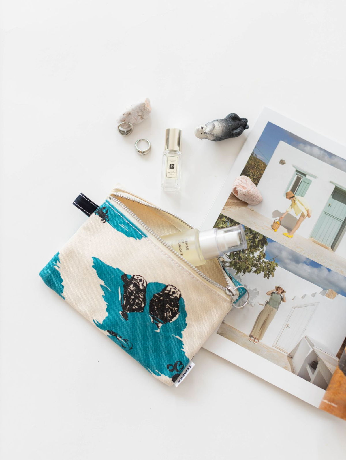 Colorful pouch with items and photographs on a white background.