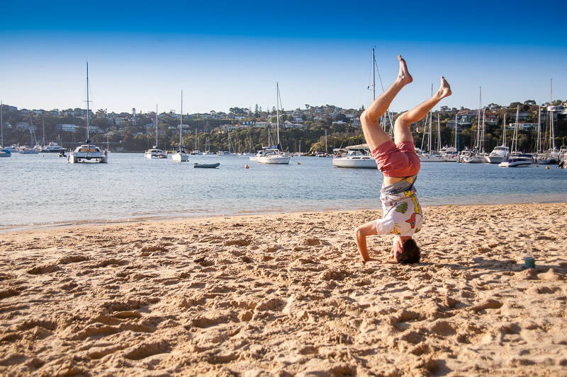 Person performing headstand on beach