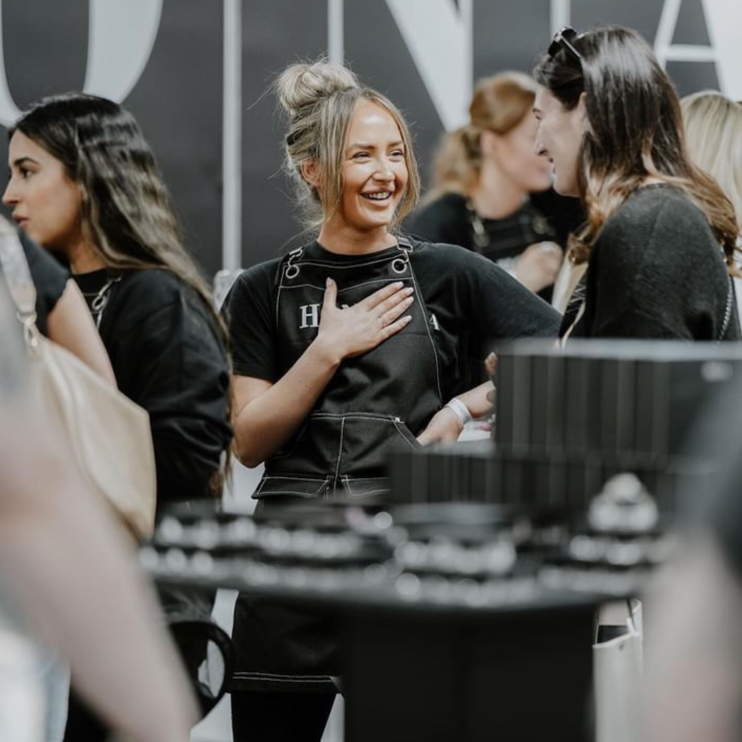 Group of people socializing at an event, one woman smiling and engaging.