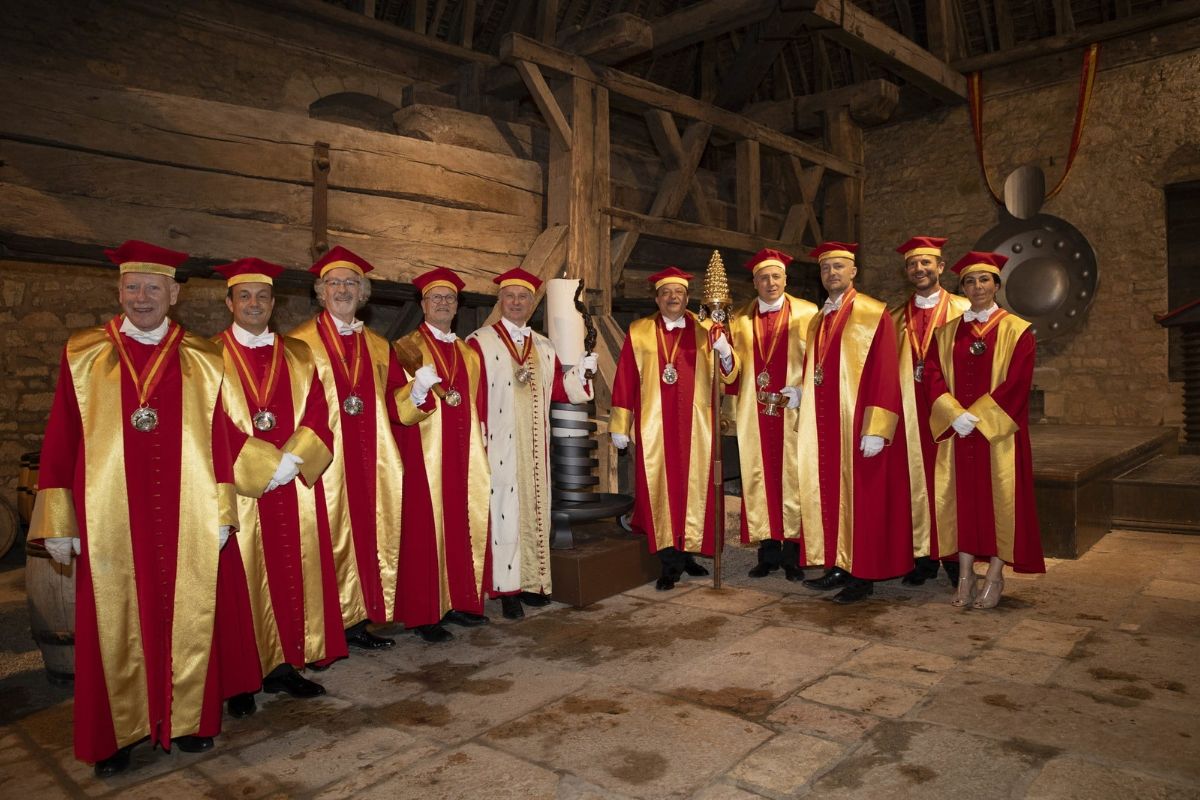 Group of individuals in formal robes standing indoors.