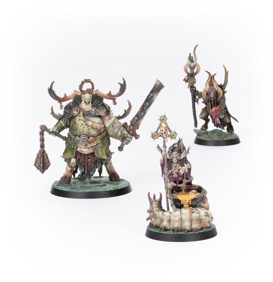 Three detailed fantasy miniatures on display, featuring intricate designs and vibrant colors.