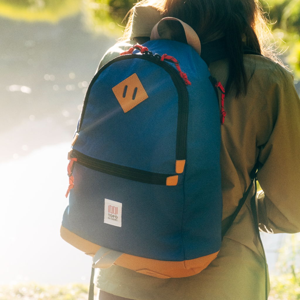 A person wearing a backpack in a natural outdoor setting.
