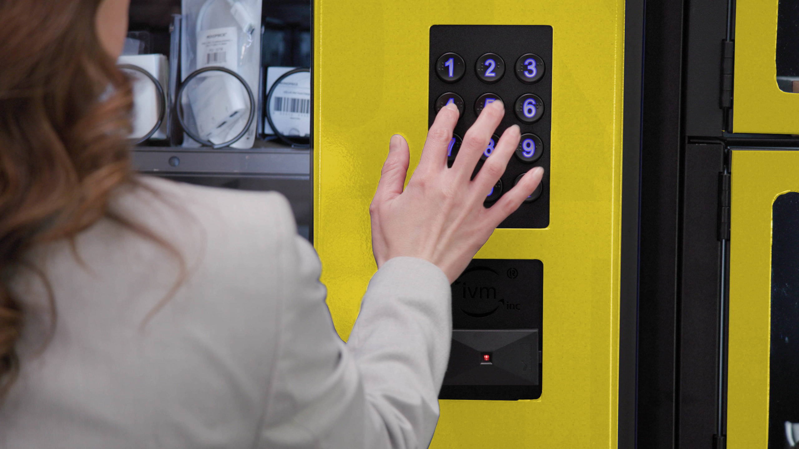 Woman using Keypad with PPE vending machine.