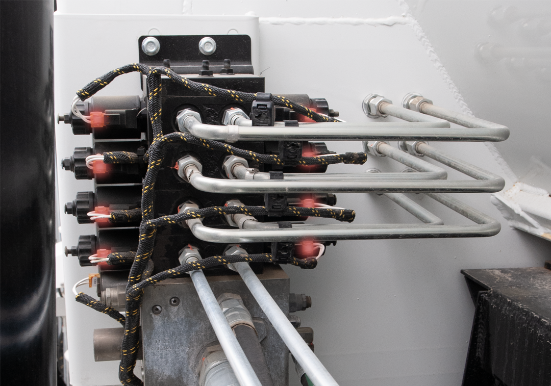 Hydraulic system components with pipes and valves mounted on a surface.