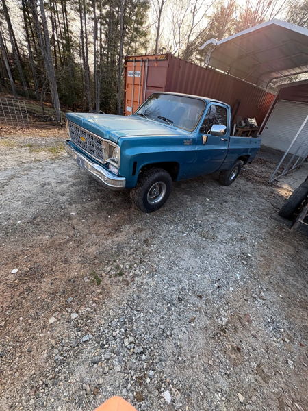 Wide front three-quarter view of Sammy's blue 1976 Chevy K10 in the gravel lot, install photo 5
