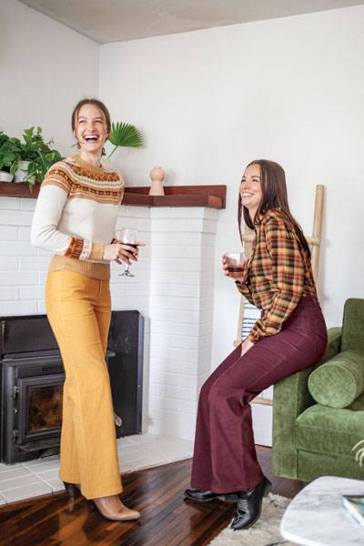 Two models laughing and holding wine glasses.