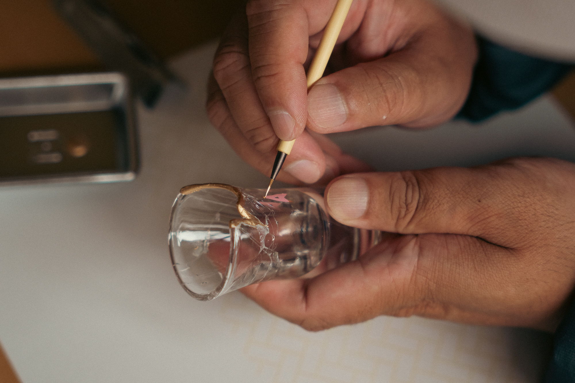 Person using a tool to work on a small glass object.