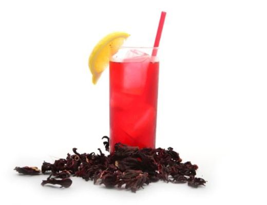 A red drink with a lemon slice on top and dried petals below.