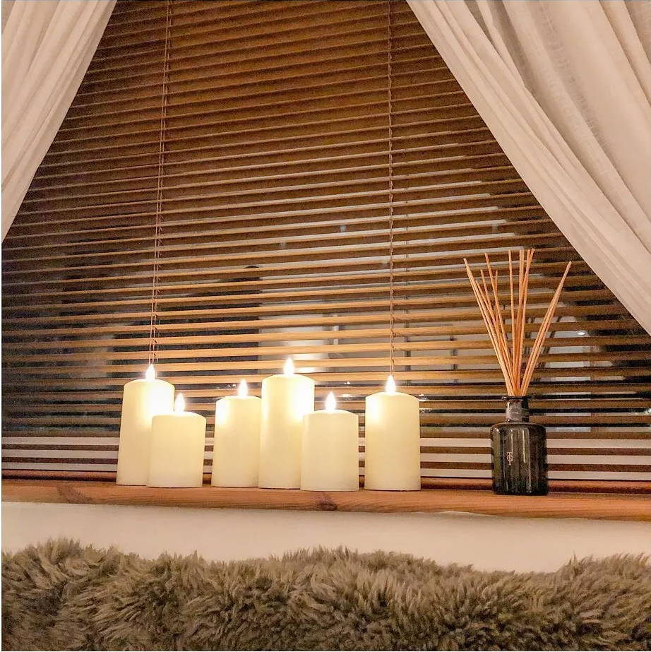 TruGlow pillar LED candles displayed on a bedroom shelf 