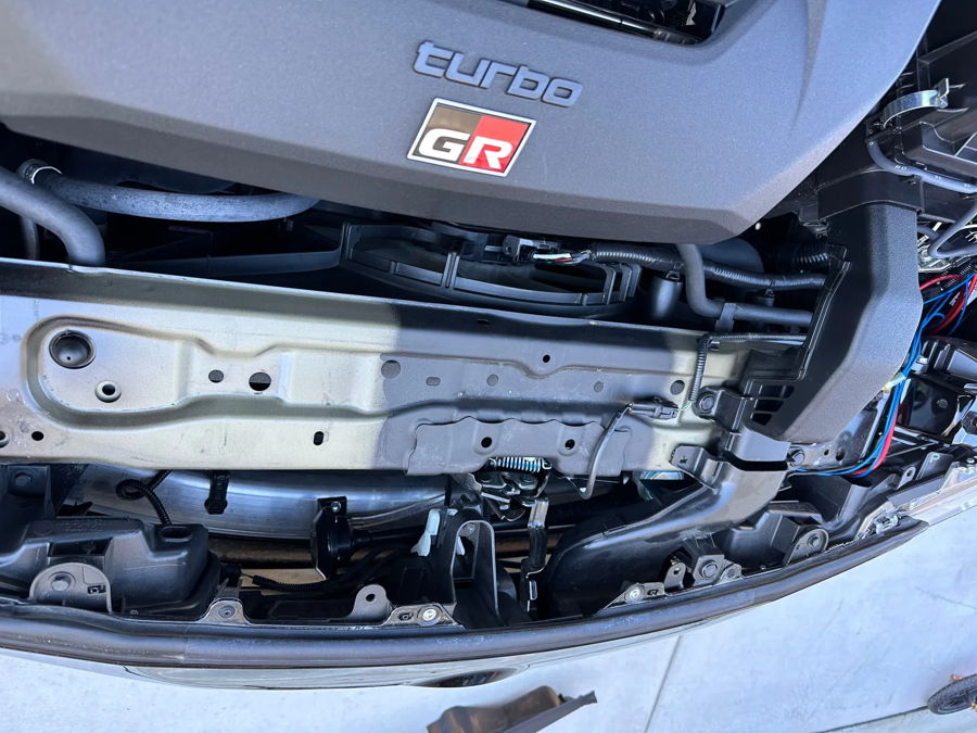 Under-grille view of horn mounting and wiring behind front bumper on 2024 Toyota GR Corolla Sniper electric horn gallery photo 4
