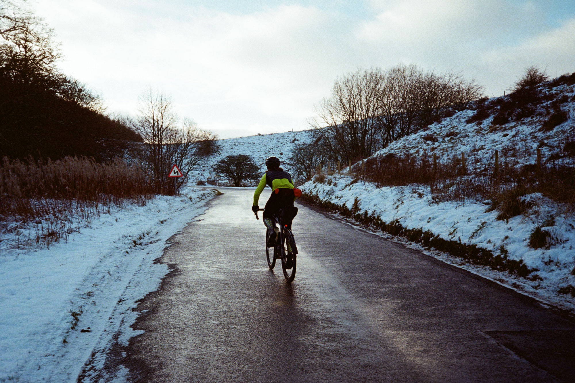 Cyclist riding up a climb in the snow