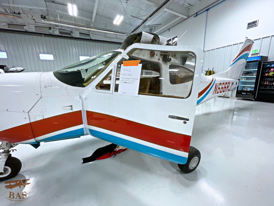Single-engine aircraft with red and blue accents in a hangar.