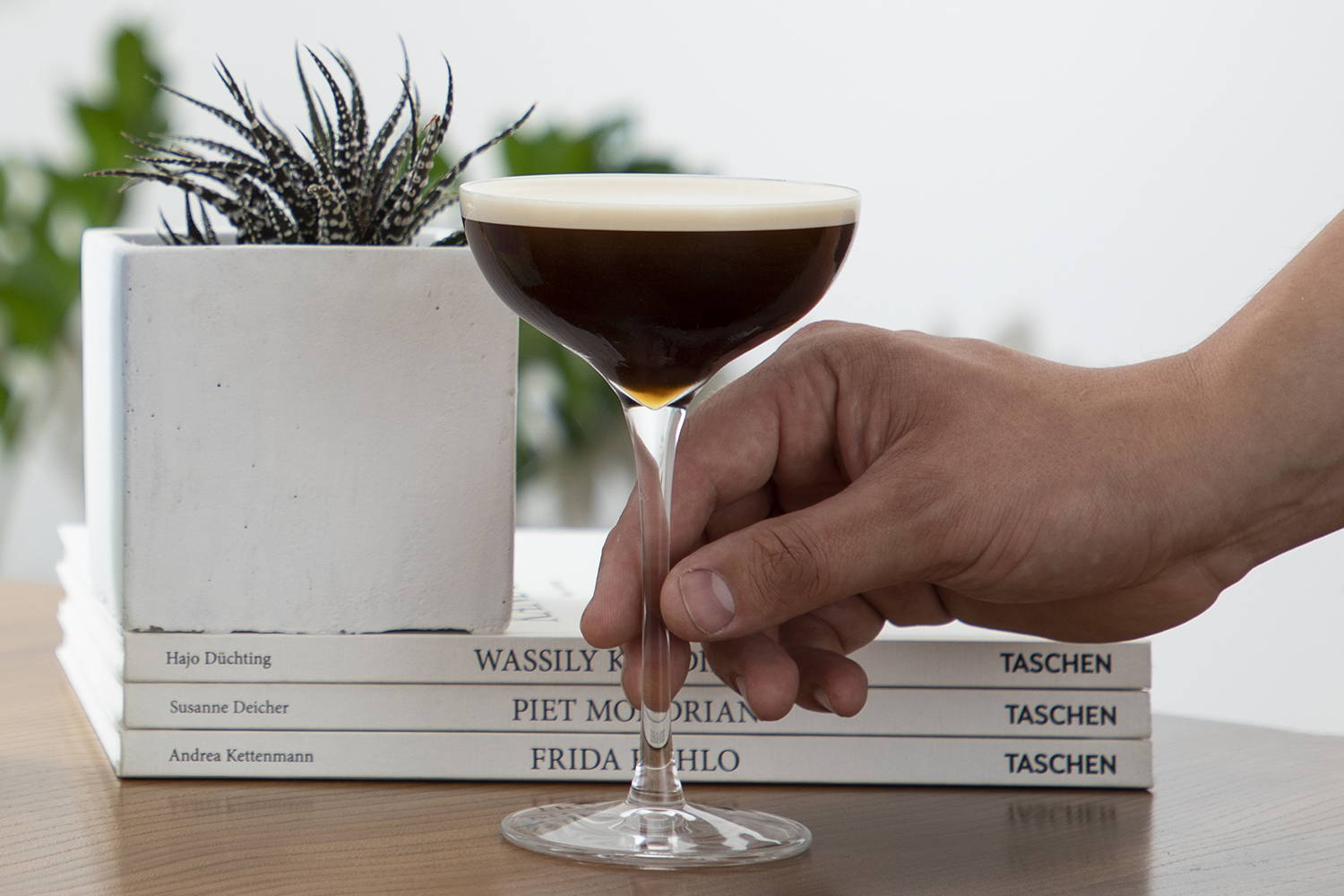 Espresso Martini cocktail with handing reaching in to pick it up