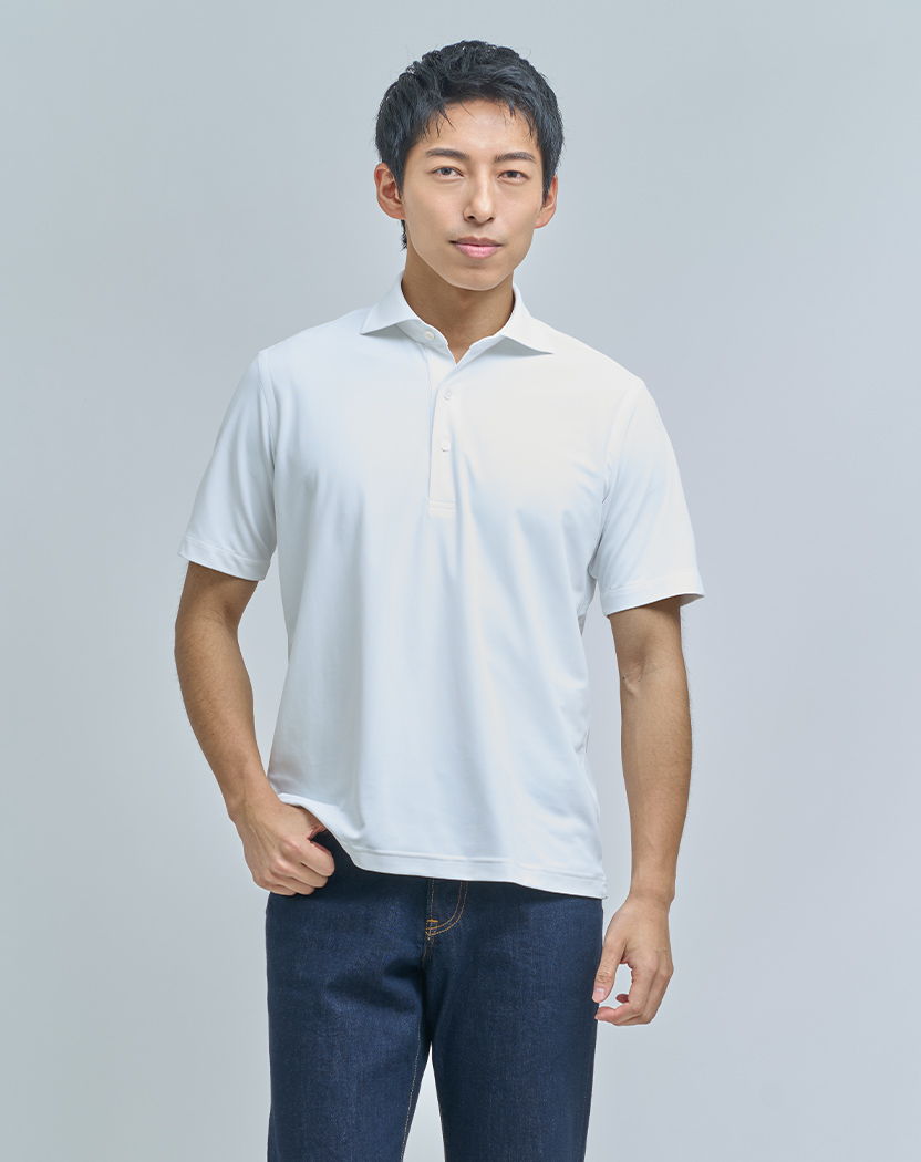 A young man in a white polo shirt and jeans, standing confidently.