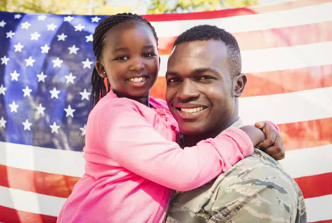 Military man in his uniform holding his daughter. Haier Military Discount Program