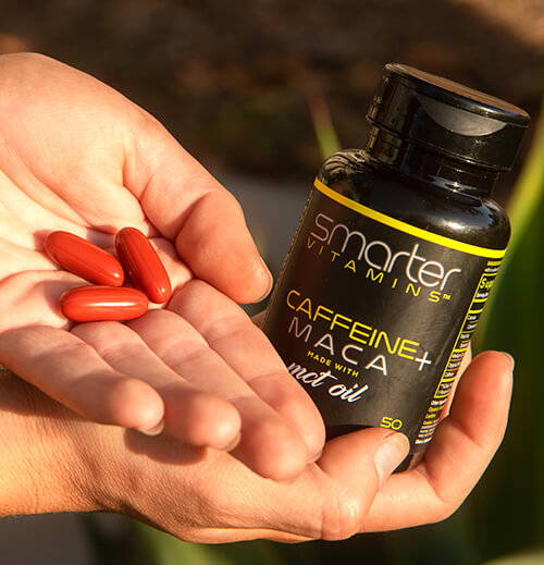 Closed smarter Caffeine MACA in one hand, showing vitamins in the other hand.
