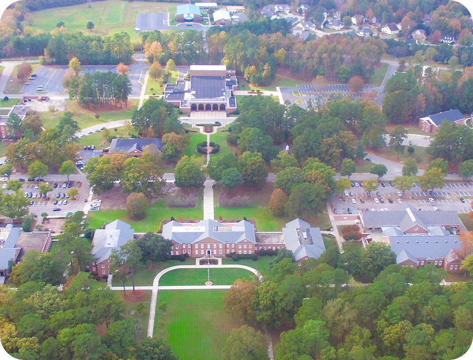 Aerial view of a campus with buildings and trees.