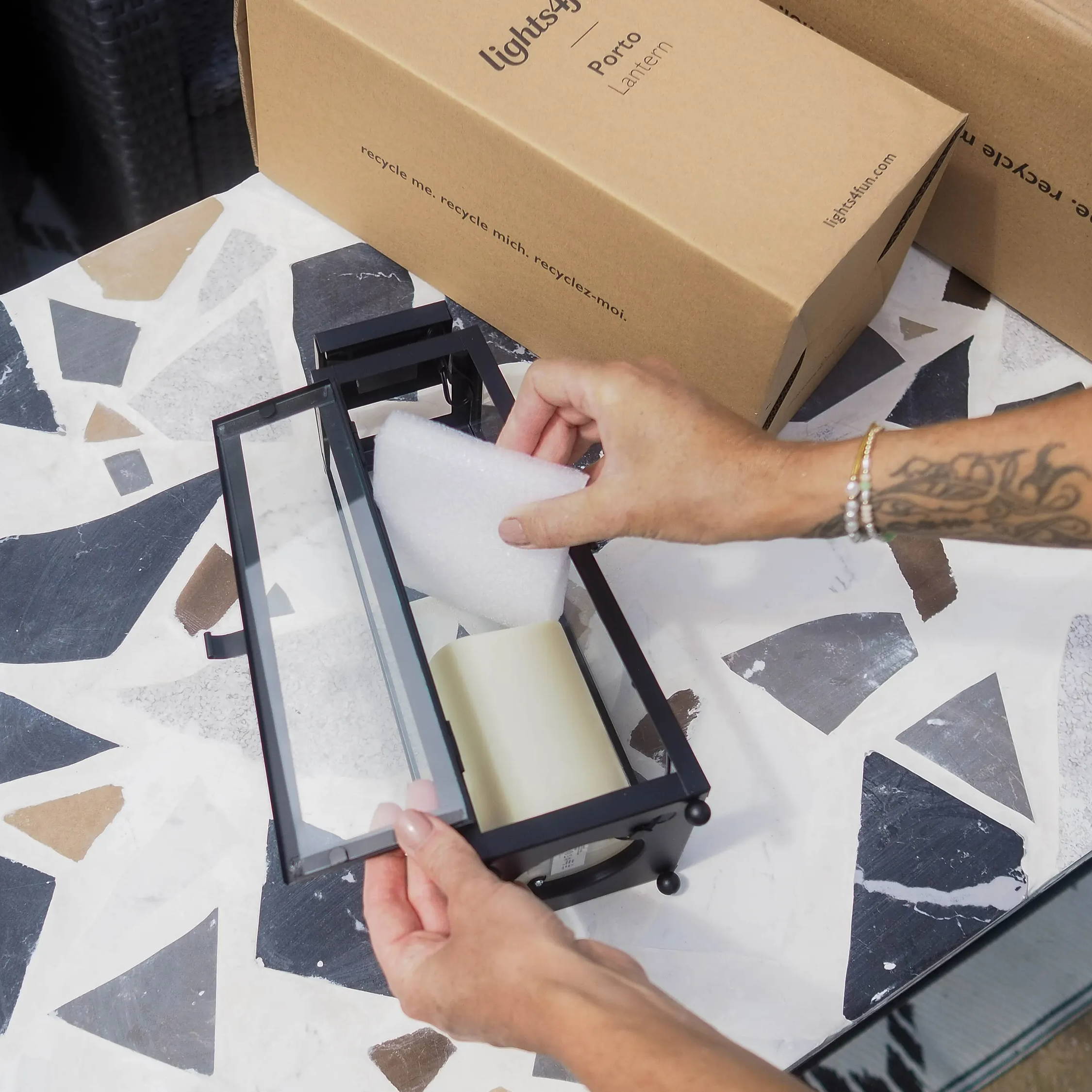 Person removing the packaging from inside a solar lantern.