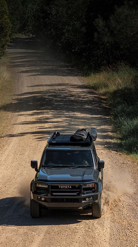 Yakima LockNLoad Platform on a 4WD driving down a dirt road.