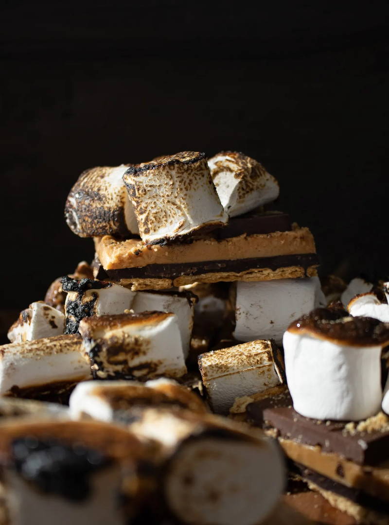 Peanut Butter & Horchata S'mores Bars stacked and covered in toasted marshmallows and melted chocolate.