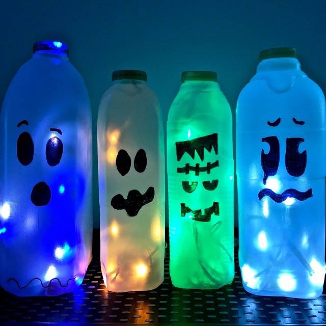 Blue green and yellow light up milk cartons with spooky faces.