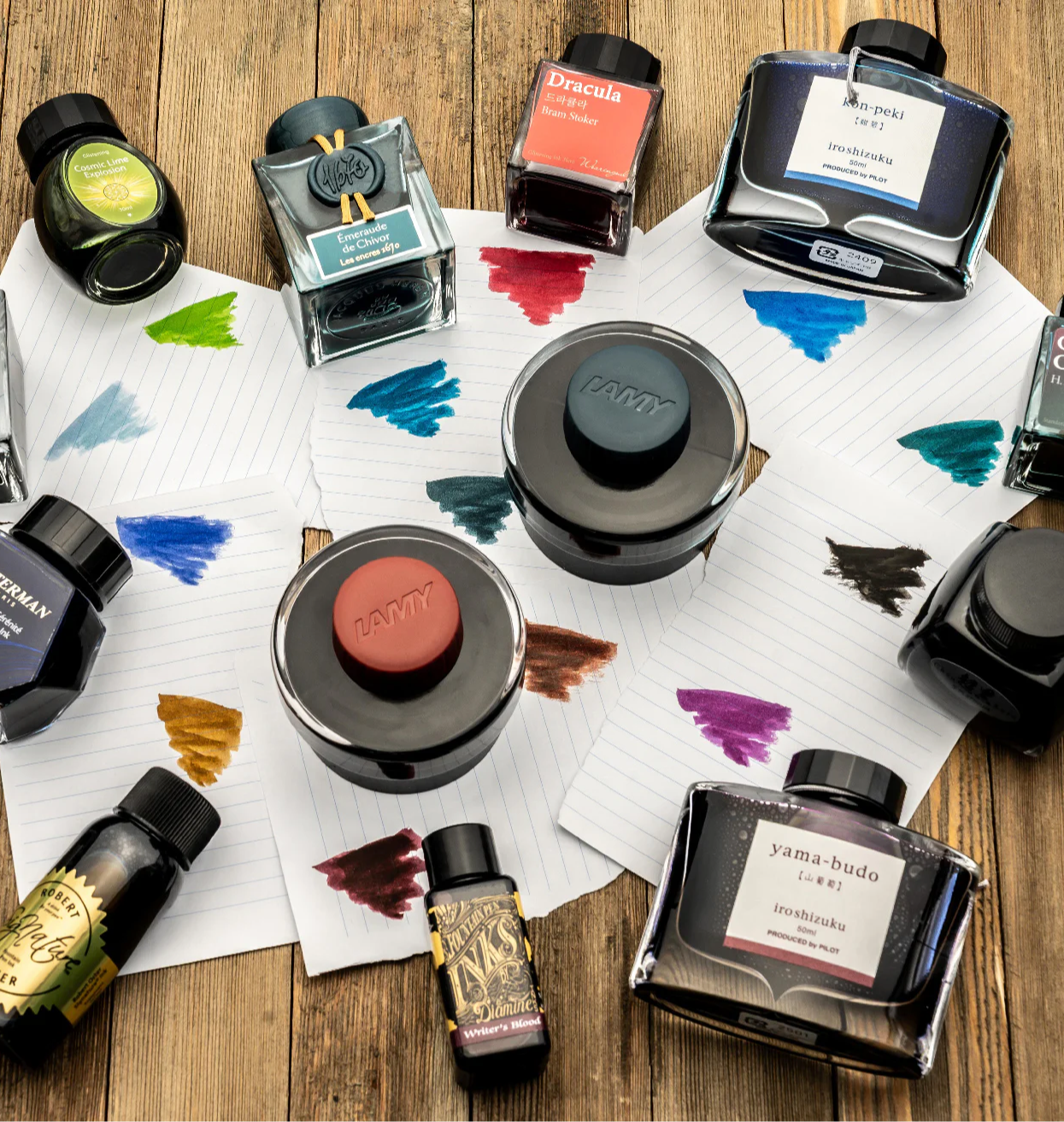 A Variety of Fountain Pen Ink Bottles and Ink Color Swatches on Paper