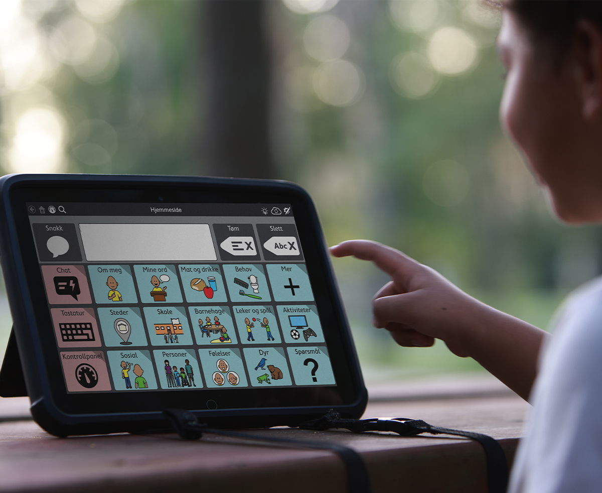 Child interacting with AAC device outside