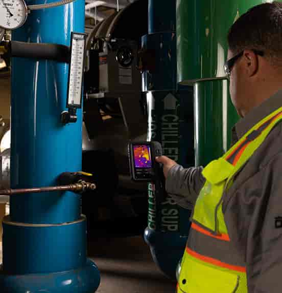 Technician using a FLIR iXX Series thermal camera to inspect industrial chiller equipment | GoThermal