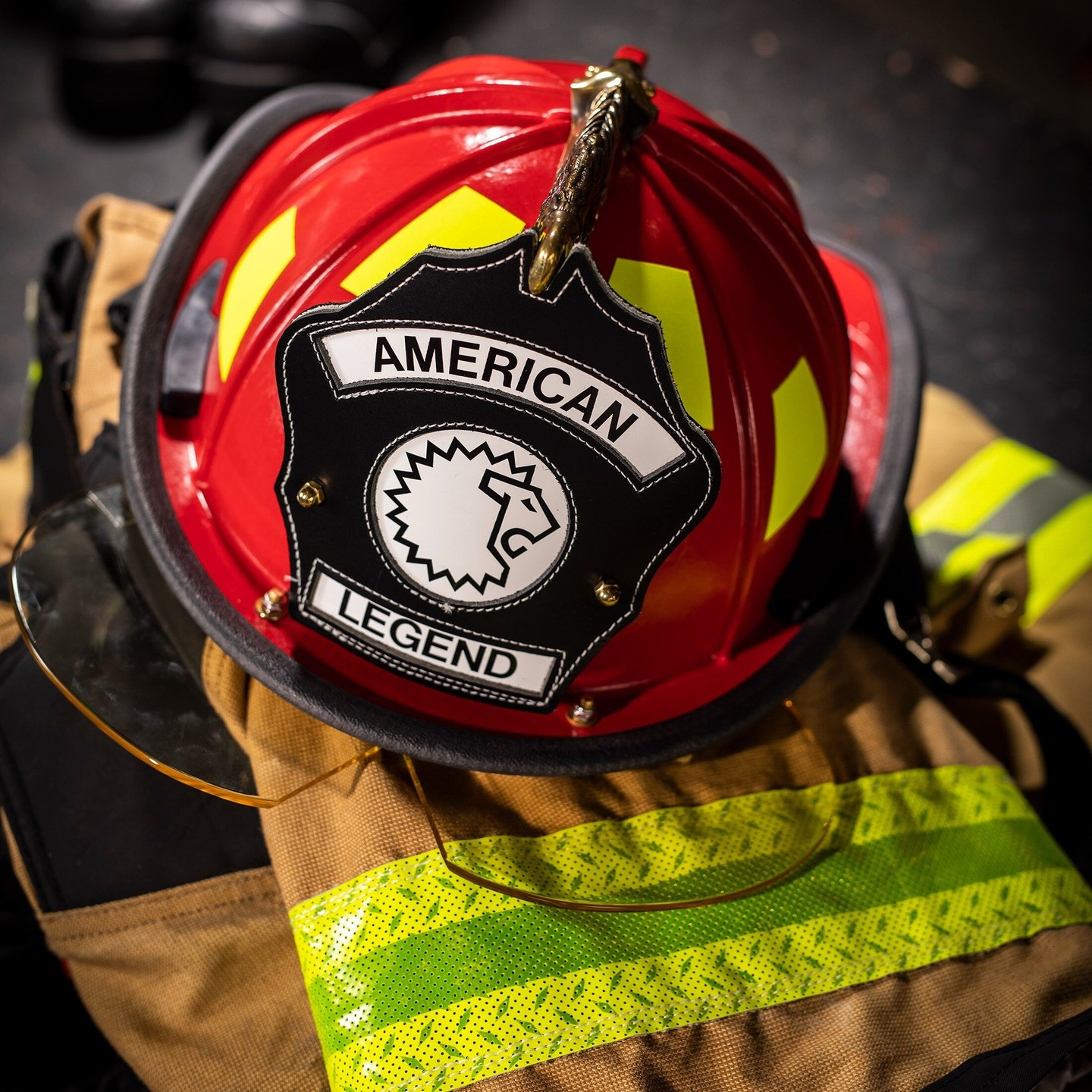 Red firefighter helmet on top of a yellow and black uniform.