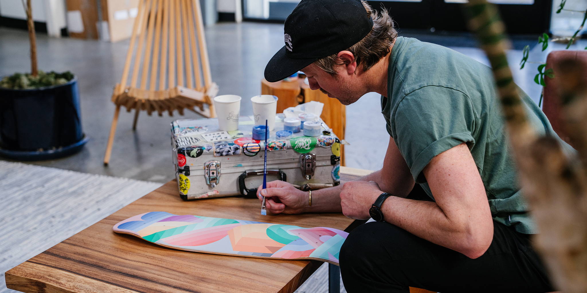 Nathan Brown in his element, painting on the back of a skateboard in his signature style.