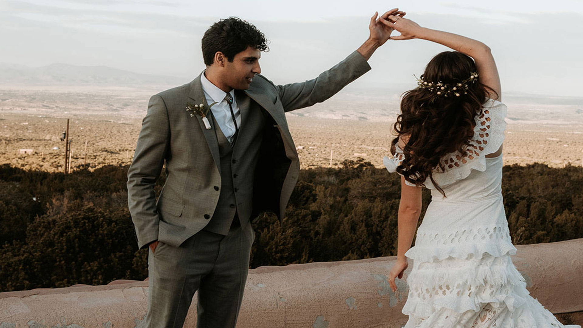 Groom twirling Bride on mountain top