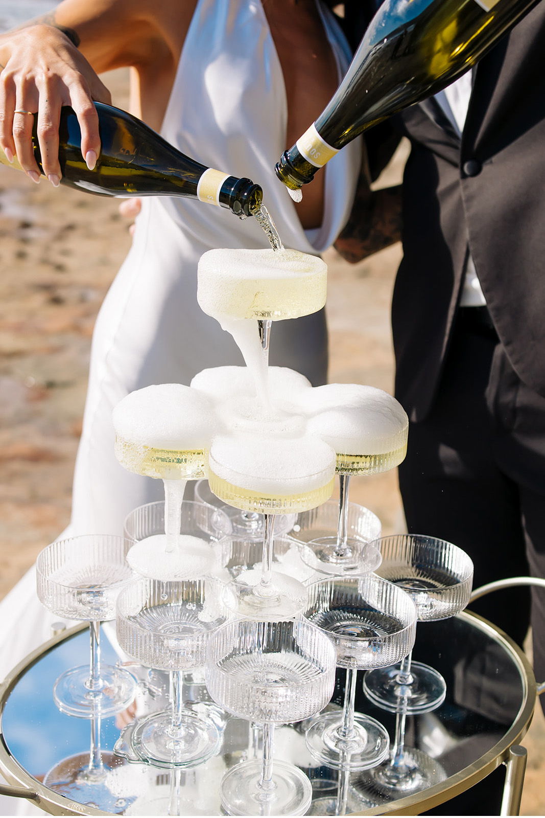 Champagne being poured into a pyramid of glasses at a celebration.