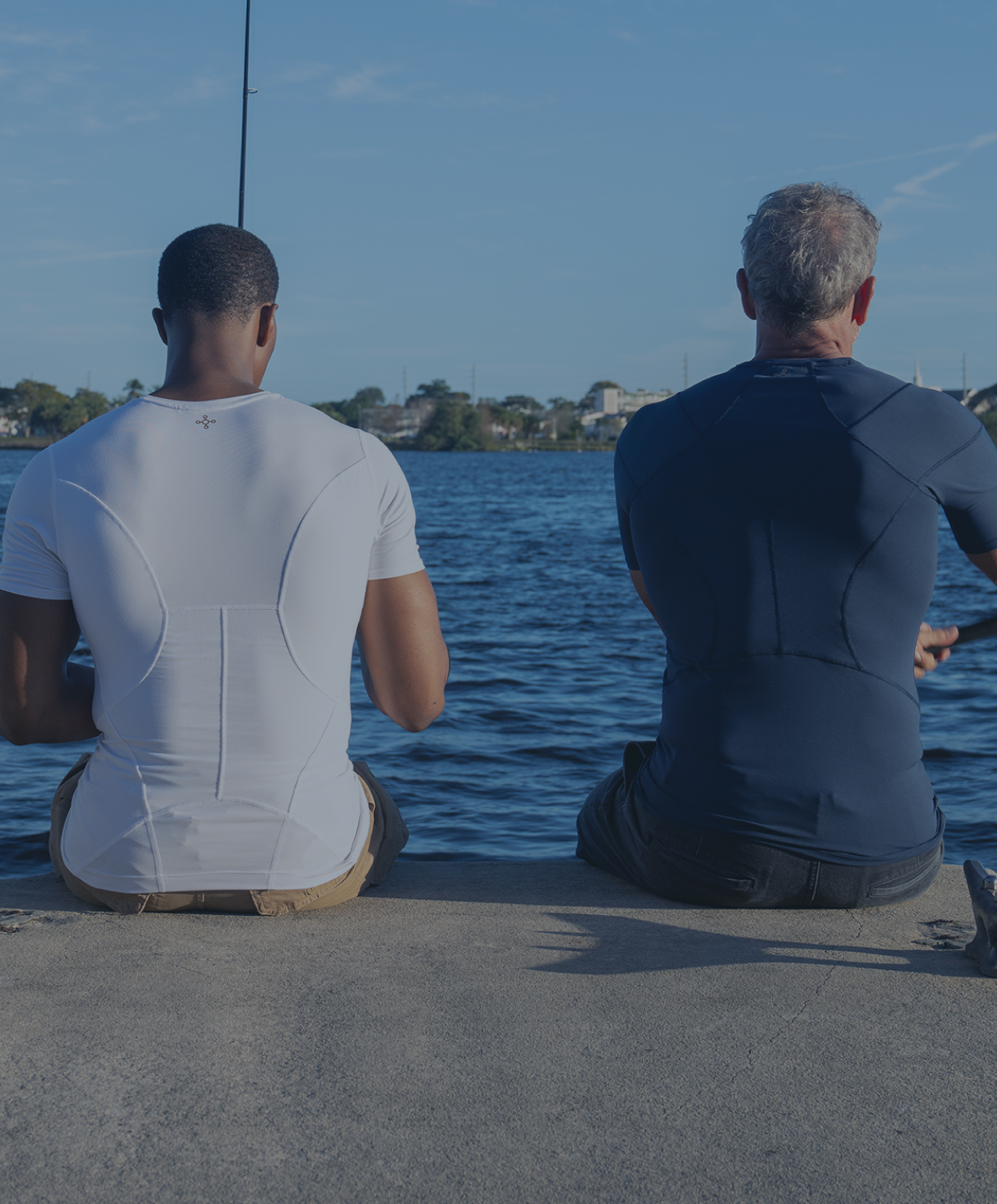 Two men fishing wearing Tommie Copper support shirts