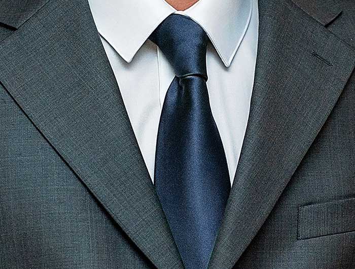 Navy blue necktie worn with a gray suit