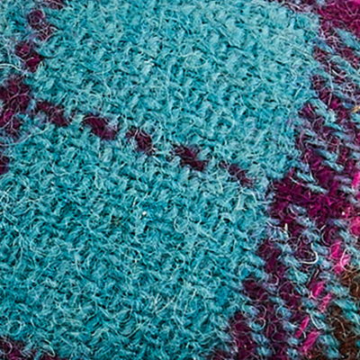 Turquoise, teal and purple Harris Tweed fabric with contrasting woven texture.