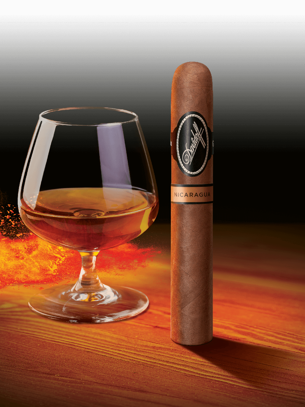 Eine Davidoff Nicaragua-Zigarre, die neben einem Glas mit Whisky steht.