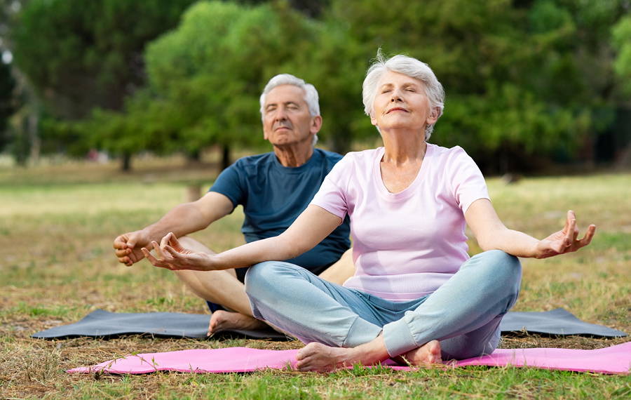 two people doing yoga in the park