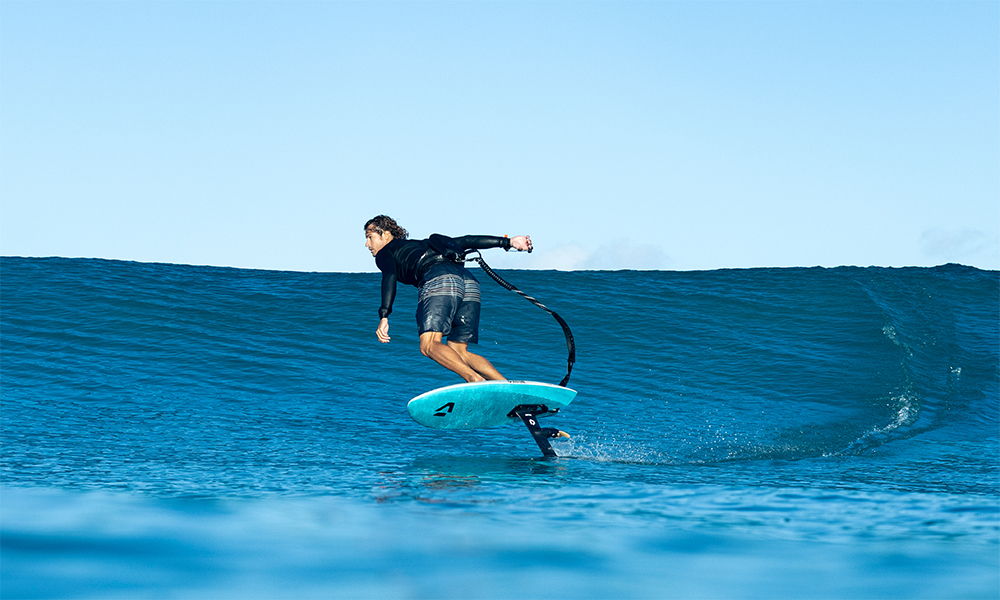 Un surfeur chevauchant une vague sur une planche de surf bleue.