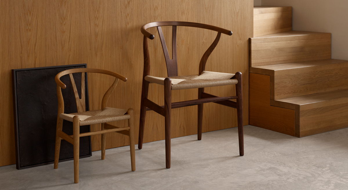 Two wooden chairs, one large and one small, against a wooden wall.