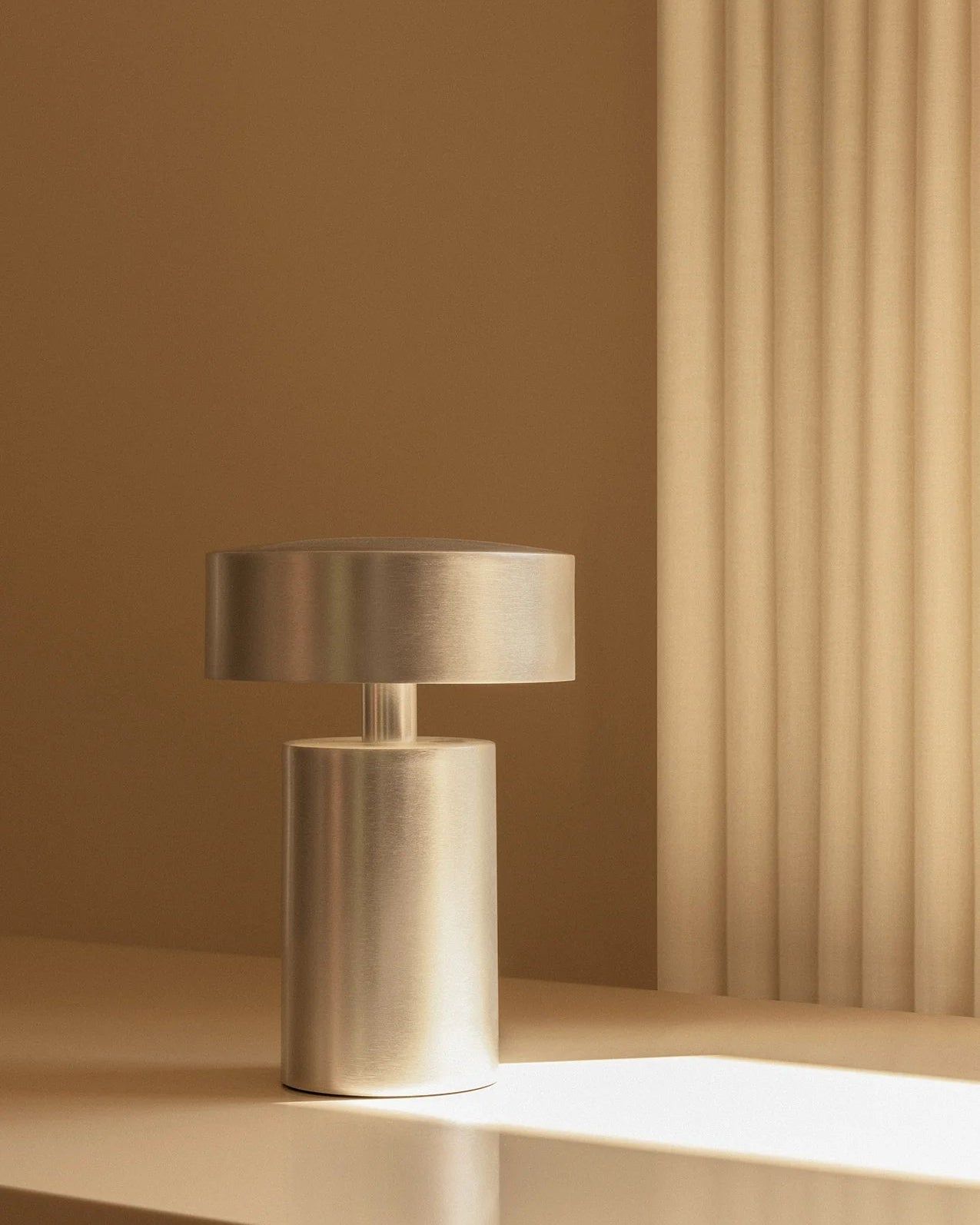 Modern metallic table lamp on a neutral background