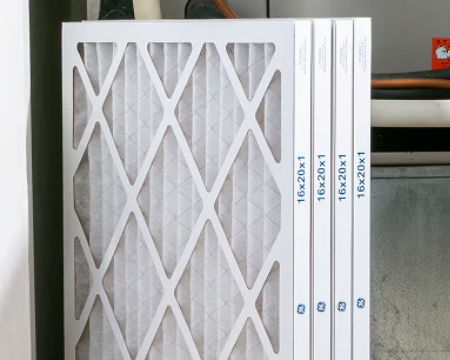 Air filters stacked next to a furnace unit.