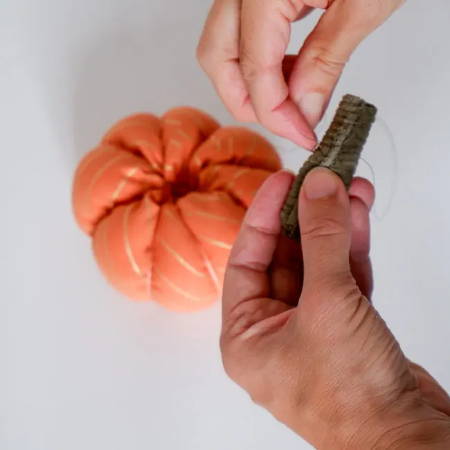 Hand-sewing the stem for the fabric pumpkin