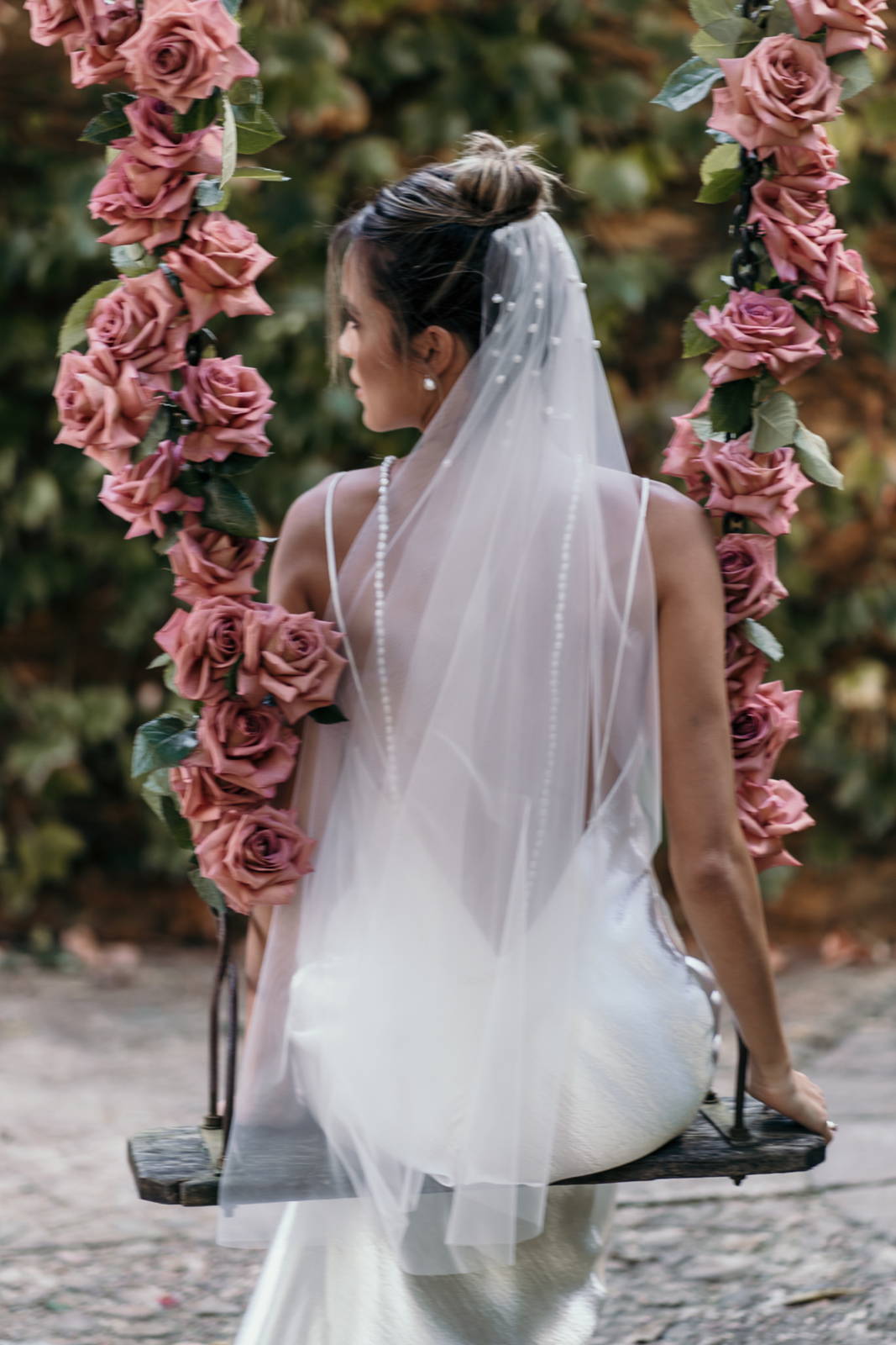  Bride on a swing adorned with pink flowers