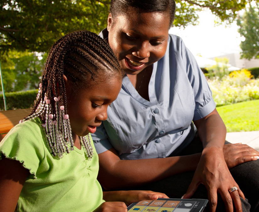 Young girl communicating with her mother on a Tobii Dynavox AAC device