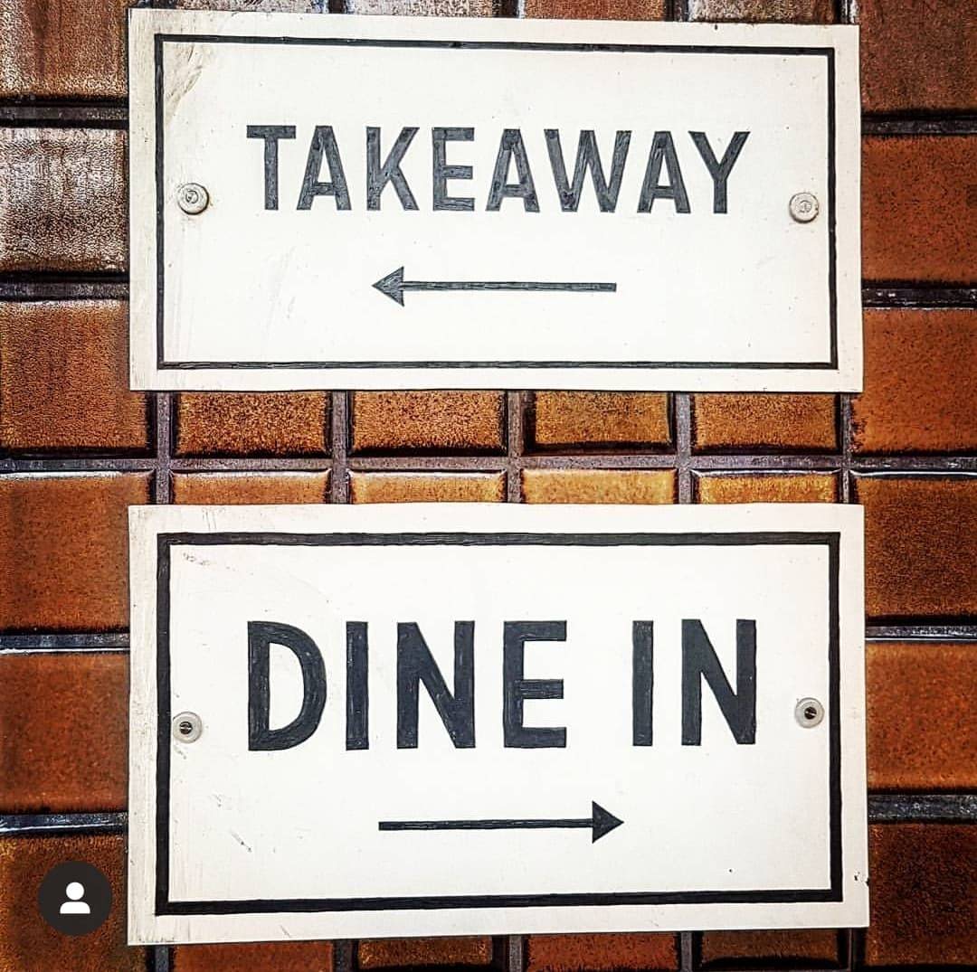 Two signs on a wall - dine in or take away