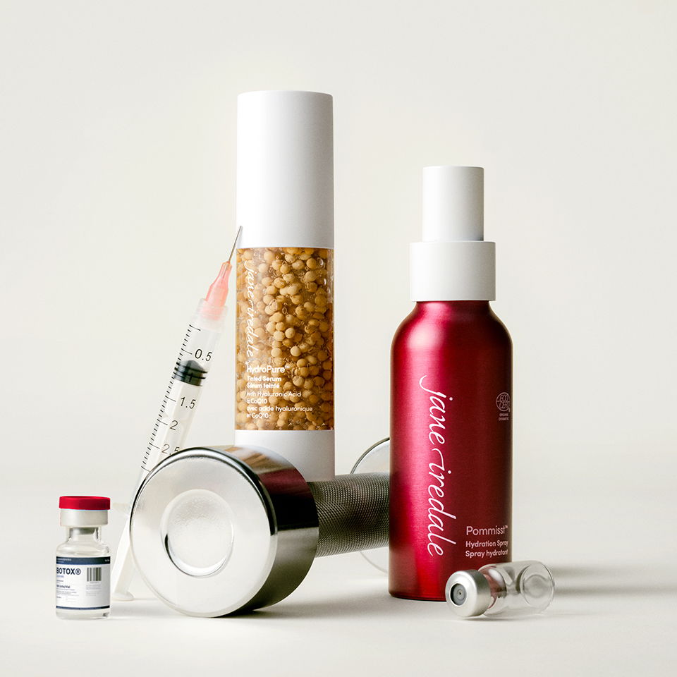 Cosmetic products including spray, vial, and container arranged aesthetically.